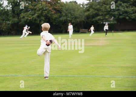 Scuola lettore della gioventù in fase di riscaldamento per il villaggio di gioco di cricket nel Regno Unito in estate Foto Stock