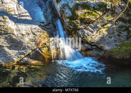 Vista ingrandita della piccola cascata sul fiume attuale alla luce del sole ( lunga esposizione ) Foto Stock