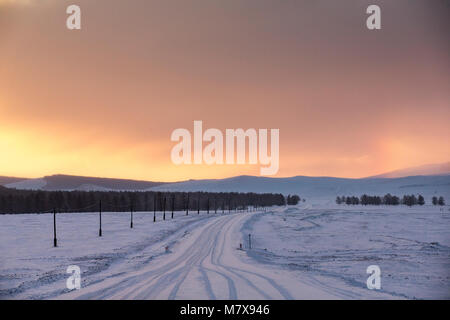 Tramonto in un nord innevato paesaggio mongolo Foto Stock