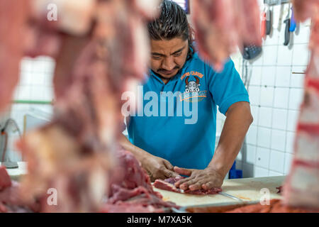 Oaxaca, Oaxaca, Messico - un lavoratore tagli carne al Mercado Zonal Las Flores, un mercato di prossimità in Las Flores quartiere. Foto Stock