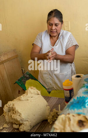 Oaxaca, Oaxaca, Messico - Gloria Hernandez Angeles rende tortillas presso il suo negozio in Mercado Zonal Las Flores, un mercato di prossimità in Las Flores Foto Stock