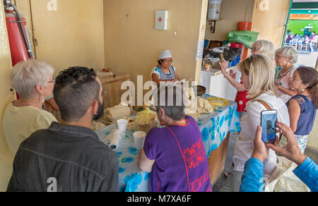 Oaxaca, Oaxaca, Messico - Modesta Hernandez Angeles colloqui per i visitatori americani circa le tortillas ella fa presso il suo negozio in Mercado Zonal las Flore Foto Stock