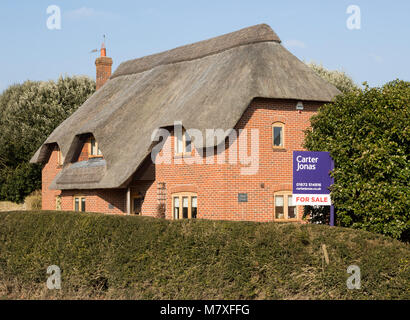 Paese di paglia cottage in vendita con Carter Jonas agente immobiliare segno esterno, Alton Priors, Wiltshire, Inghilterra, Regno Unito Foto Stock