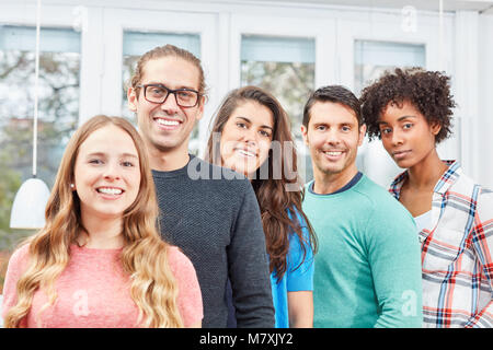 Un gruppo di giovani studenti costituisce un contesto multiculturale community di Office Foto Stock