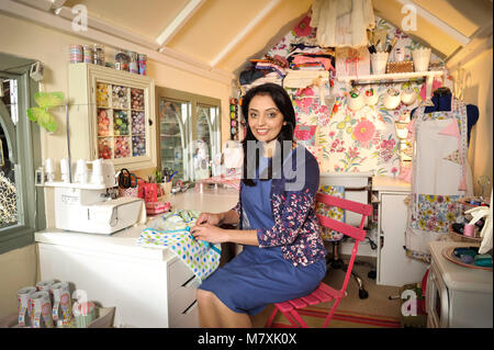 Manjit Sidhu nella foto con lei-capannone in cui ella si prende il tempo per cucire. Foto Stock