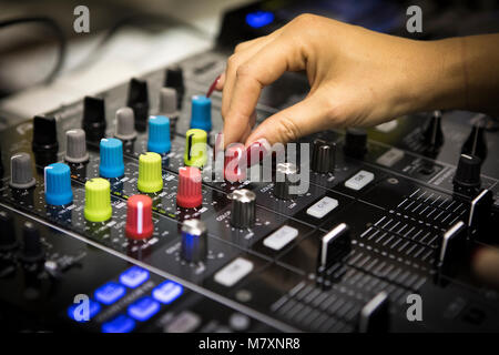 DJ femmina con le unghie rosse su CDJ e mixer. Foto Stock