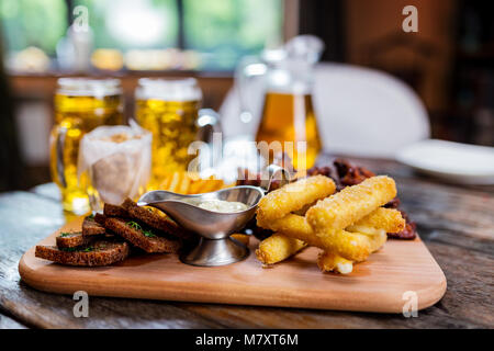 Un assortimento di snack di birra con boccali da birra Foto Stock