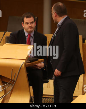 MSP Mark McDonald (sinistra) riconosce verde scozzese MSP Andy Wightman come egli si siede sul retro della camera al suo ritorno il parlamento scozzese di Edimburgo dopo le sue dimissioni dal suo ruolo ministeriale e del SNP dopo aver ammesso il comportamento inadeguato verso le donne. Foto Stock