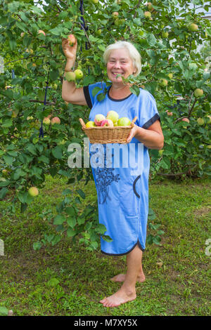 Coppia Allegra donna in giardino con le mele. Agosto Foto Stock