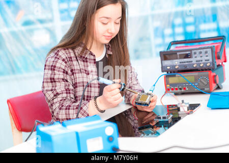 Schoolgirl in robot di laboratorio microcontrollore di debug Foto Stock