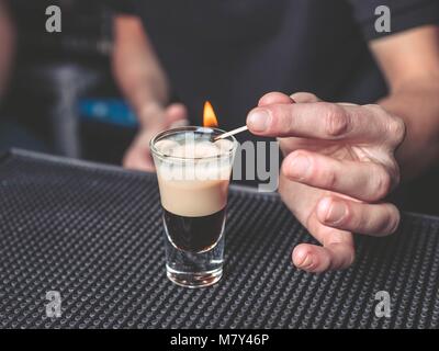 Barman flaming cocktail B-52 sulla barra Foto Stock