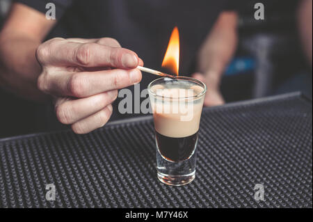 Barman flaming cocktail B-52 sulla barra Foto Stock