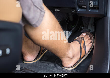 Chiudere il piede destro con flip flop calzatura passo sull'acceleratore nell'auto moderna Foto Stock