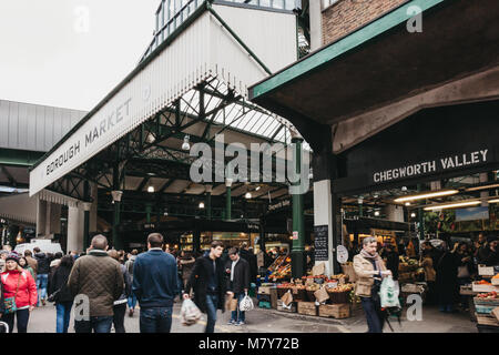 La gente a piedi dall'ingresso al mercato di Borough, uno dei più grandi e più antiche i mercati alimentari a Londra. Foto Stock
