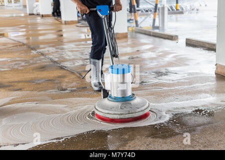 Lavoratore asiatico sabbia pulizia lavare passerella esterna utilizzando la macchina di lucidatura e chimico o di acido Foto Stock