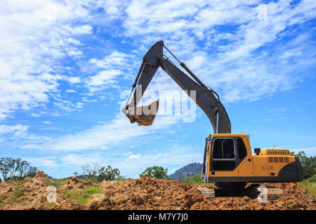 Lavoro all'aperto : escavatore scavo per lo spostamento del suolo per il carrello e la regolazione del livello del terreno in sito in costruzione. Foto Stock