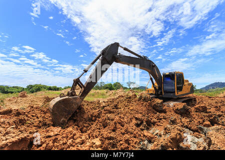 Lavoro all'aperto : escavatore scavo per lo spostamento del suolo per il carrello e la regolazione del livello del terreno in sito in costruzione. Foto Stock