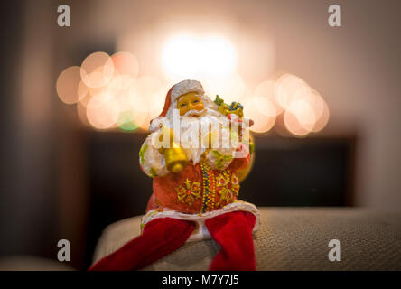 Santa Claus bambola e le decorazioni di Natale sulla luce astratta sfondo. Foto Stock