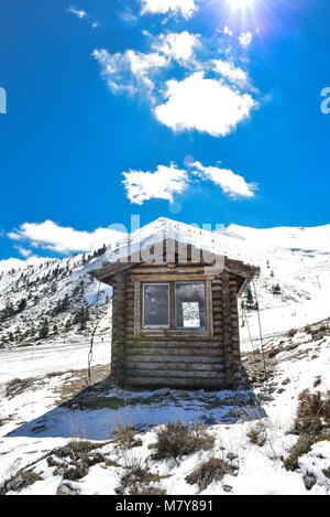 In inverno il paesaggio innevato con cabina hut amd cielo blu e nuvole sulla montagna vicino Helmos Kalavryta città in Grecia Foto Stock