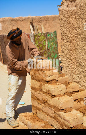 Il Saharawi uomo costruisce un mattoni di fango casa a Smara, Sahawi campo profughi in Algeria. Foto Stock