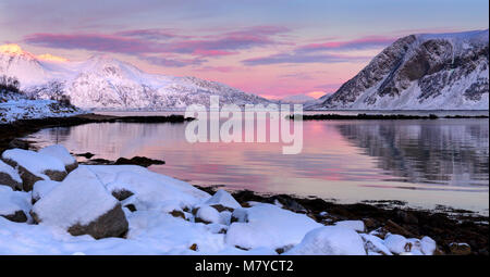 Una vista al tramonto su Ersfjord, Norvegia settentrionale, con cielo rosa e riflesso nell'acqua. Foto Stock