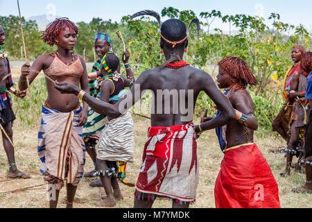 Un Hamar Tribesman si prepara a frusta Hamar giovani donne durante un 'proveniente dall'età' Bull Jumping cerimonia, Dimeka, Valle dell'Omo, Etiopia Foto Stock