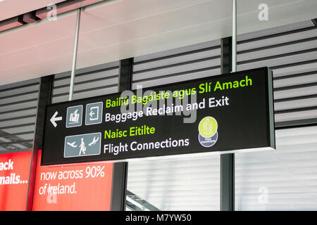 Segnaletica bilingue in irlandese e inglese a Dublino Aeroporto (Aerfort Bhaile Atha Cliath), Repubblica di Irlanda Foto Stock