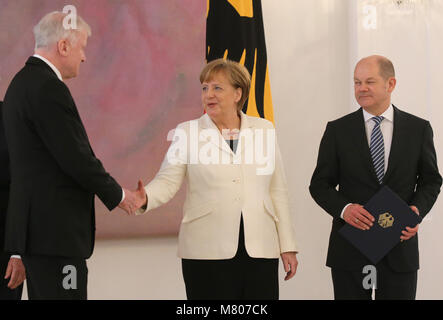 Berlino, Germania. Xiv Mar, 2018. 14.03.2018, Berlin: Germania il Cancelliere Angela Merkel (CDU) si congratula con Horst Seehofer (l, CSU), per la sua nomina a ministro degli interni a im Schloss Bellevue. Sulla destra è il ministro delle finanze Olaf Scholz (SPD). Credito: Wolfgang Kumm/dpa/Alamy Live News Credito: dpa picture alliance/Alamy Live News Credito: dpa picture alliance/Alamy Live News Foto Stock