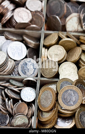 Cashbox in legno pieno di lira sterlina monete Foto Stock