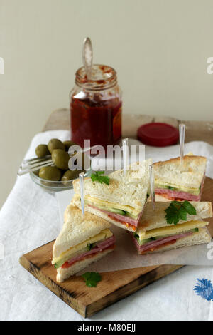 Panini con salsiccia, carne, formaggio e verdure fresche su una tabella con olive e ketchup. Foto Stock