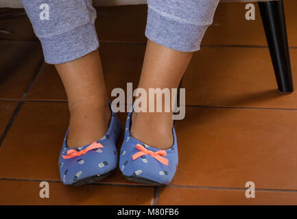 Piedi in pantofole di una persona seduta su una sedia immagine con spazio copia in formato orizzontale Foto Stock