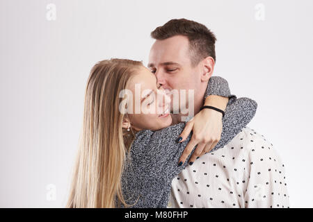 Giovane uomo baciare donna bionda isolato su sfondo bianco Foto Stock