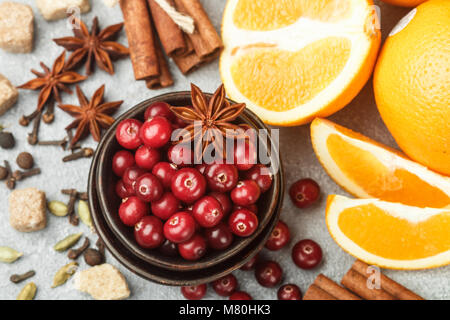 Gli ingredienti per cucinare piccante tradizionale bevande invernali - cranberry, agrumi, cannella, cardamomo, anice stellato, chiodi di garofano e pepe. Analcoliche vin brulé Foto Stock