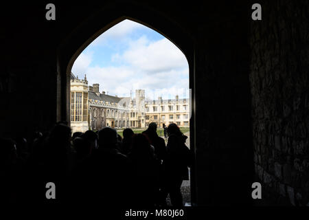 Un gruppo di studenti nel Queens Gate" che si affaccia sulla grande corte al Trinity College di Cambridge University, Inghilterra, su una soleggiata giornata invernale. Foto Stock