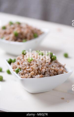 Chiudere fino sulla ciotola di bollito grano saraceno sulla tavola di legno tabella Foto Stock