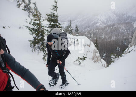 Escursioni con le racchette da neve in montagna nella neve profonda Foto Stock