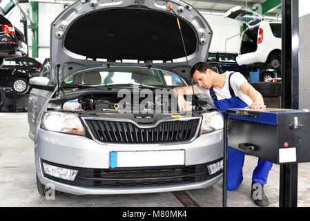 Regolazione dei fari sulla vettura da meccanica in un garage Foto Stock