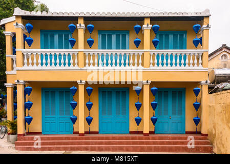 Un giallo e blu di edificio con lanterne blu in Hoi An, Vietnam Foto Stock