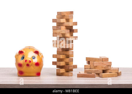 Pila di blocchi di legno e di gioco Salvadanaio su un tavolo di legno. Studio shot e isolato su sfondo bianco Foto Stock