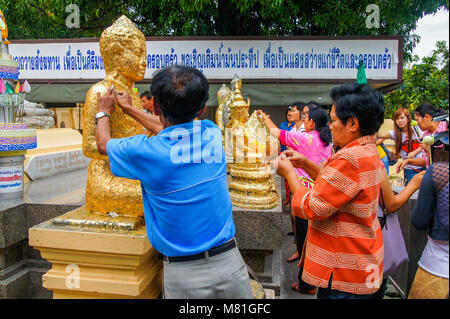 Nakorn Pathom, Tailandia - 10 Giugno 2012: buddisti di doratura foglia oro sulla faccia della statua del Buddha al culto di Buddha nel tempio buddista in Nakorn pato Foto Stock