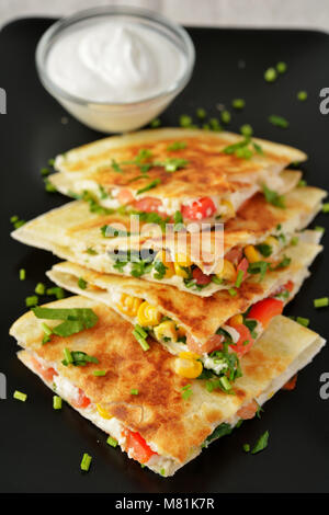 Vegetariano quesadilla con panna acida. Messa a fuoco selettiva sul cuneo anteriore Foto Stock