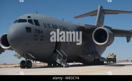 Miniera-resistente agguato veicoli protetti sono caricati su un C-17 Globemaster III in una località segreta in Asia sud-ovest Marzo 7, 2018. MRAPS sono in grado di fornire una protezione per i servizi dei membri contro le minacce sul ciglio della strada come dispositivi improvvisati e miniere. (U.S. Air Force foto di Senior Airman Krystal Wright) Foto Stock