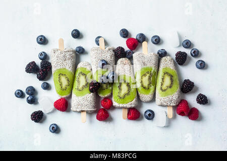 Kiwi cocco Popsicles Chia e freschi maturi frutti di bosco al mattino tavola dolci sani Foto Stock