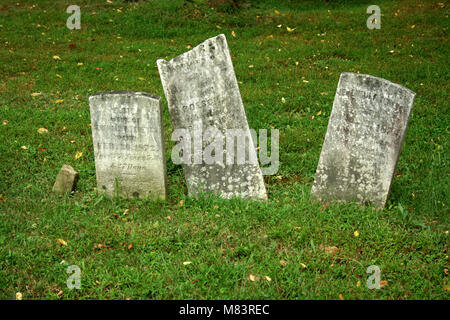 Tre vecchie lapidi con erba in un cimitero Foto Stock