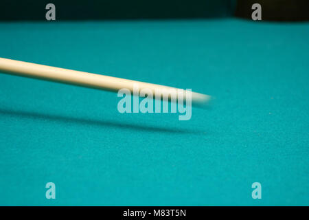 Cue stick in movimento su un tavolo verde Foto Stock