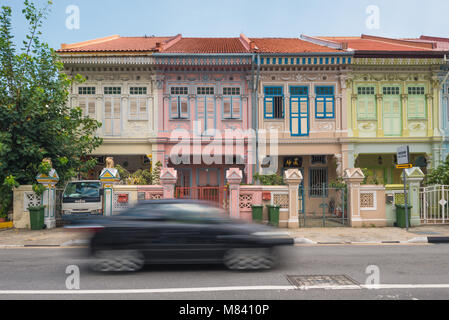 Negozio di patrimonio case lungo Joo Chiat Road. Una moderna autovettura con motion blur è all'avanguardia. Foto Stock