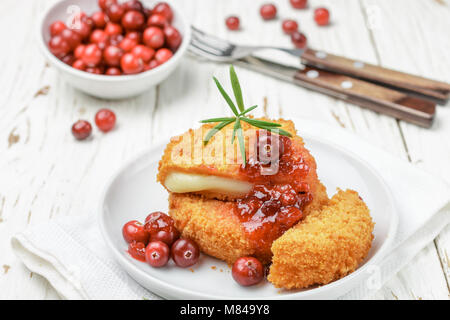 Panato al forno Formaggio Camembert (brie) con frutti di bosco freschi e salsa di mirtilli con rosmarino su uno sfondo bianco. Snack Gourmet. La prima colazione. Selective Foto Stock