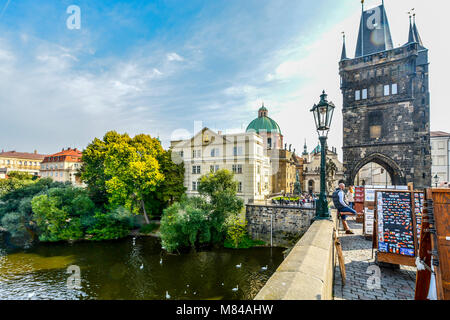 La torre del ponte della Città Vecchia di Praga, Cechia, oltre il Fiume Vltava con fornitori che vendono souvenir. Foto Stock