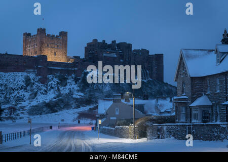 Bamburgh borgo e castello con neve invernale, Northumberland, Inghilterra. Inverno (febbraio) 2018. Foto Stock