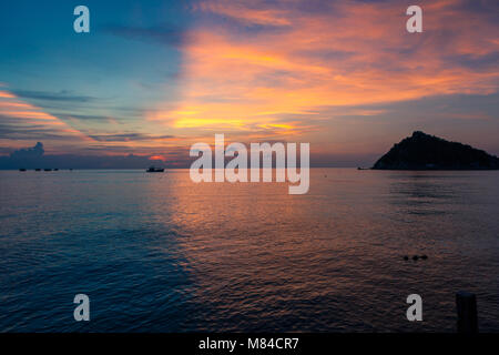 Incredibile tramonto con metà blu e metà giallo arancione e rosa cielo sopra il mare e le navi di oltre l'orizzonte. Vista dell'Isola Nang Yuan da Ko Tao Foto Stock